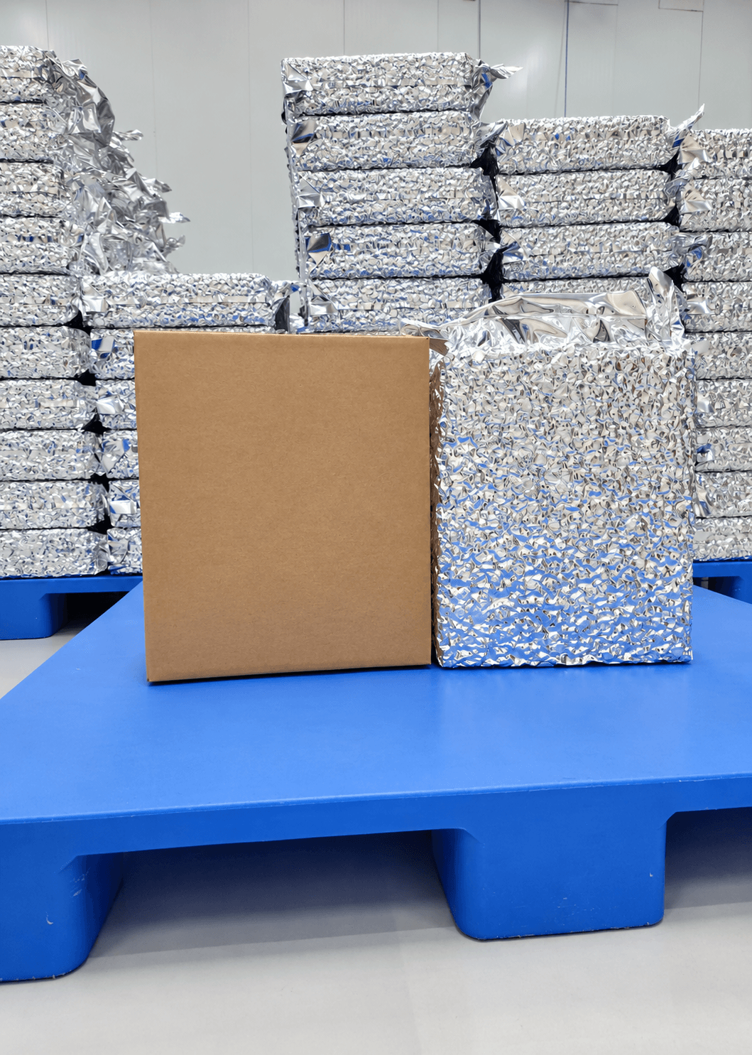 Stacked vacuum-packed cartons on a pallet with plain unbranded export packaging box
