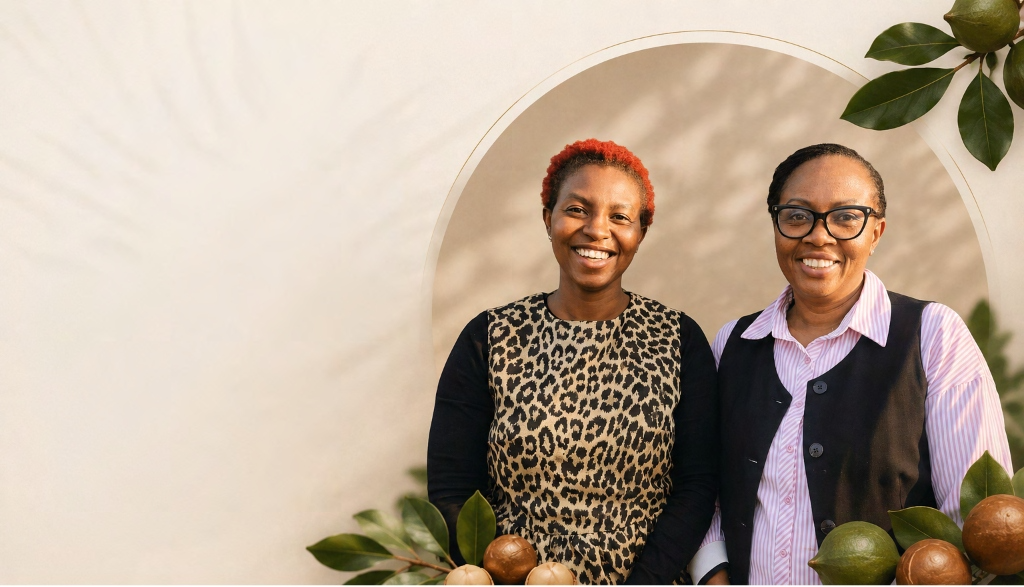 Charity Ndegwa and Jane Maigua, the two founders of Ridge & Root, standing under an arched alcove framed by macadamia branches